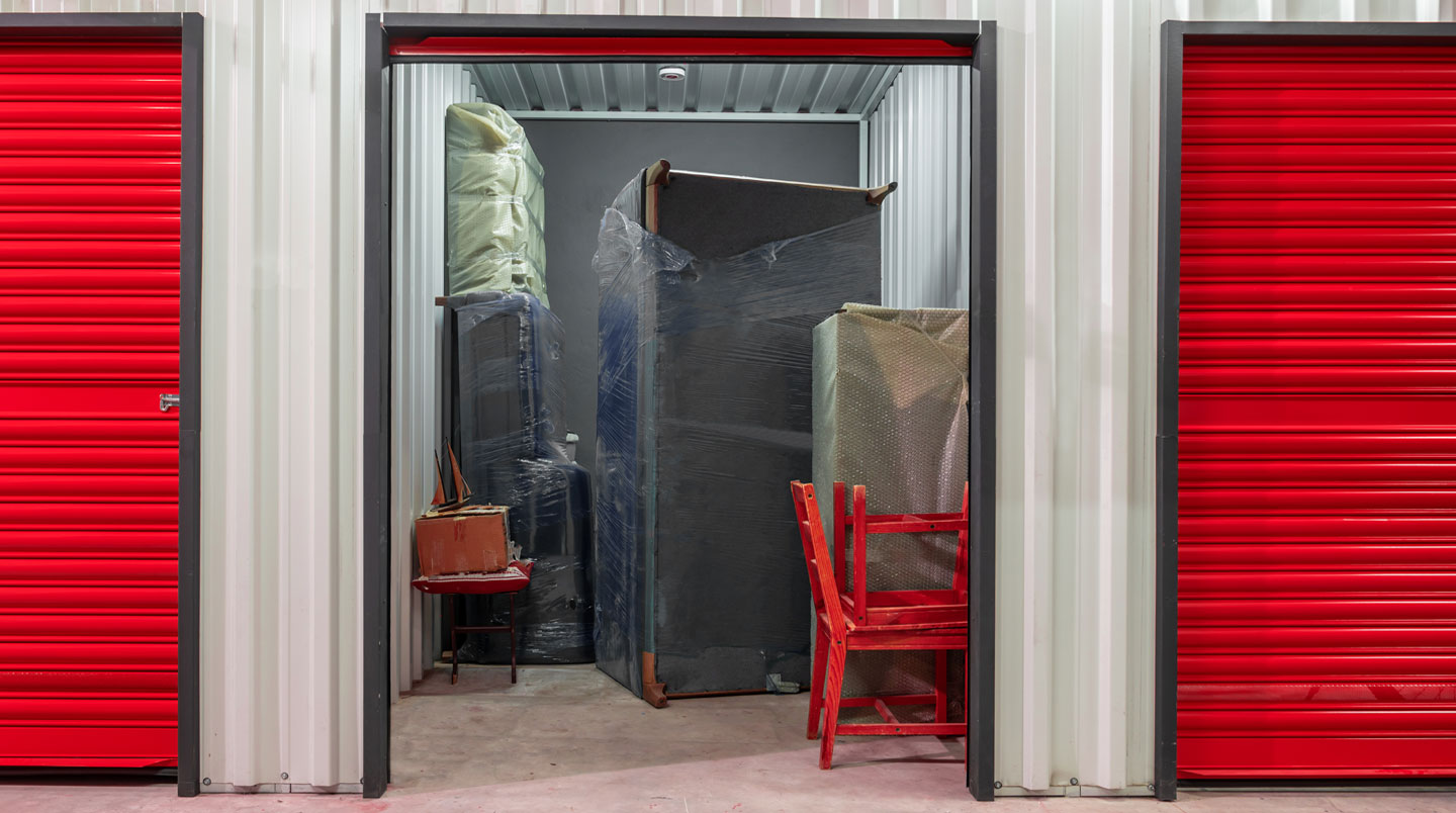 Intérieur d'un box de self-stockage avec mobilier soigneusement empilé et cartons organisés